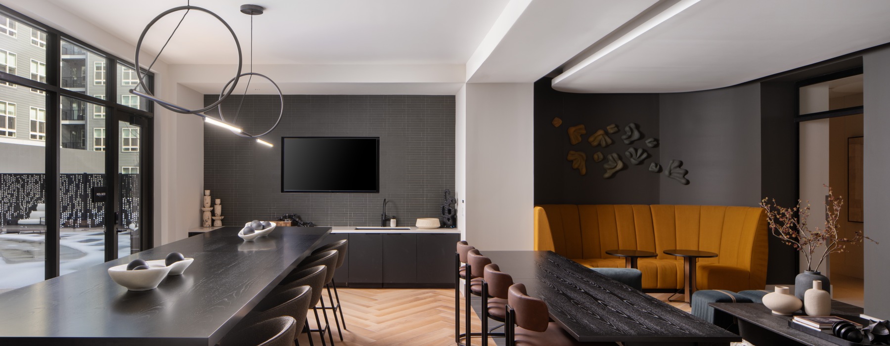 large room with a table and chairs with a wet bar and 2 tvs 