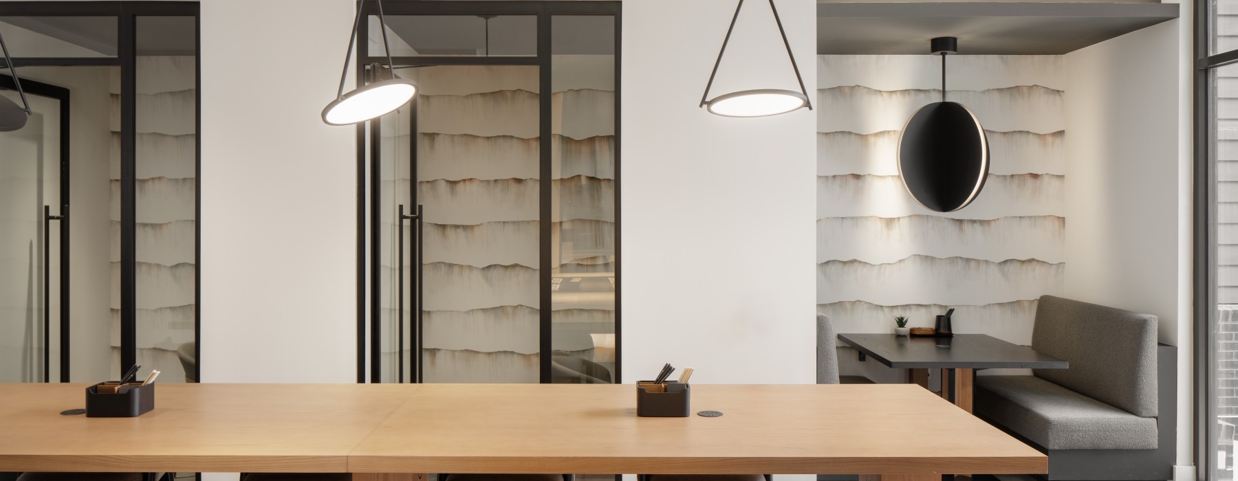 a business center with a large table and chairs a wall with private micro offices 